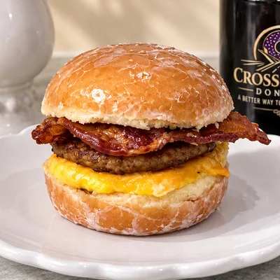 Bacon, sausage, egg, and cheese breakfast sandwich on a glazed donut