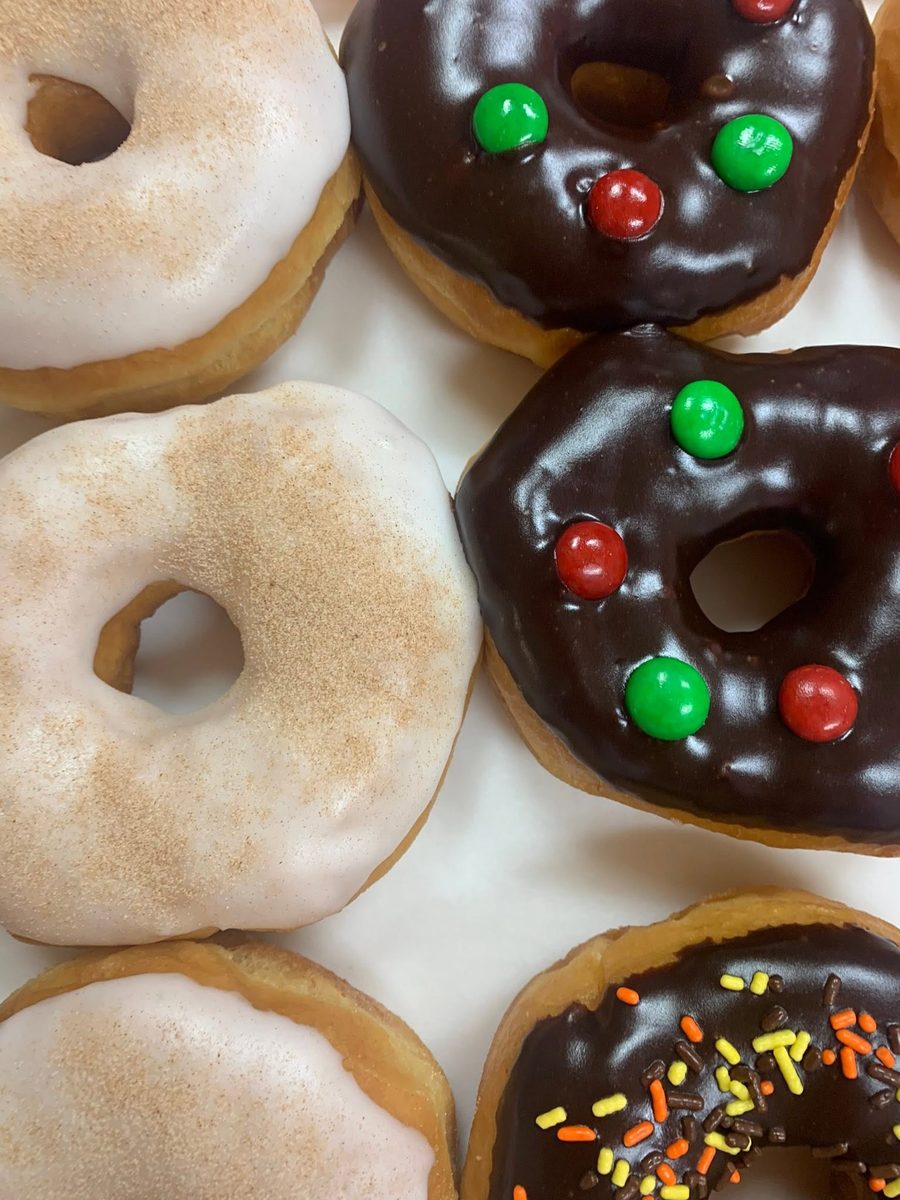 Cinnamon-glazed and chocolate-iced donuts topped with candy-coated chocolates